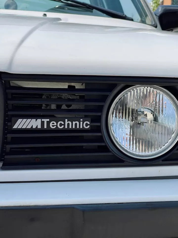 BMW ///M Technic Emblem front view showing iconic retro M design