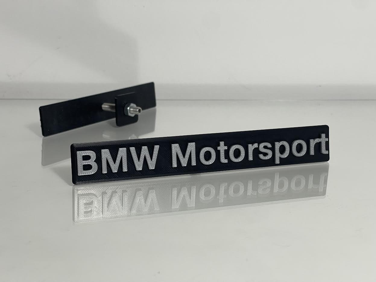 BMW Motorsport Emblem rear view showing adhesive backing or clip-on mounting